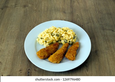 Fried Chicken Strips Wrapped In Breadcrumbs With A Simple Potato Salad