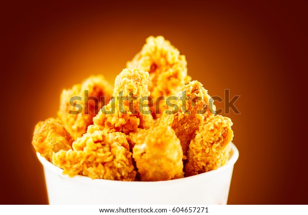 Download Fried Chicken wings and legs. Bucket full of crispy kentucky fried chicken on brown background