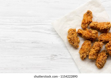 Fried Chicken Wings On Baking Paper Sheet Over White Wooden Background, Top View. From Above, Overhead. Copy Space.