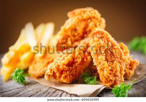 Fried chicken wings on wooden table.\
Breaded Crispy fried kentucky chicken tasty\
dinner