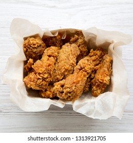 Fried Chicken Wings In Paper Box Over White Wooden Background. Top View, Overhead. Close-up.