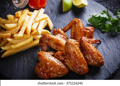 Fried Chicken Wings With Potato On Black Stone