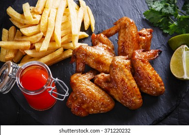 Fried Chicken Wings With Potato On Black Stone