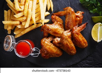 Fried Chicken Wings With Potato On Black Stone