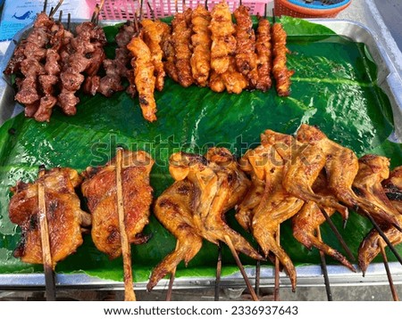 fried chikken and pork at vendor open air market in Thailand 