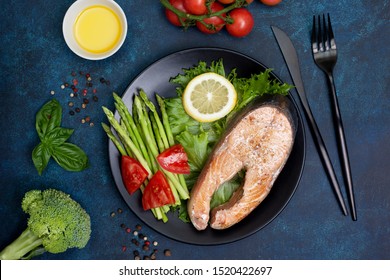 fried chum salmon and fresh vegetables on a plate on a blue background. keto diet. view from above - Shutterstock ID 1520422697