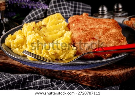 Fried cod fillet served with boiled potatoes and vegetable salad.