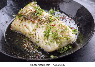 Fried Cod Fish Fillet With Spice And Cress As Close-up In A Cast Iron Pan 