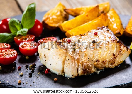 Fried cod loin with baked potatoes and vegetables