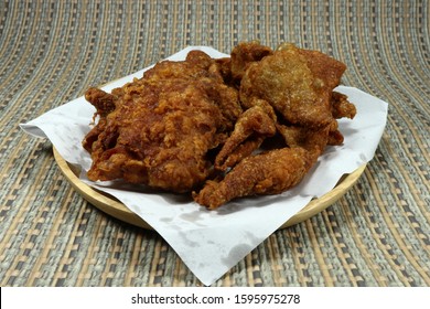Fried crispy chicken on wood plate with Oil-blot sheet paper. Famous appetizer menu in party. Street food with fat and high cholesterol. Unhealthy menu.