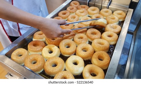 Fried Donts In The Stove With Human Hand To Turn The Donut Up Side Down