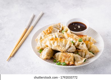 Fried dumplings gyoza with soy sauce, and chopsticks, selective focus.