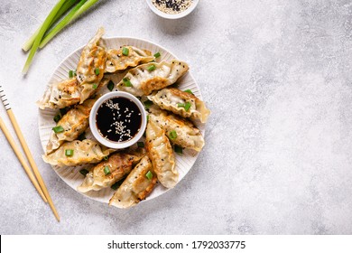 Fried dumplings gyoza with soy sauce, and chopsticks, top view.