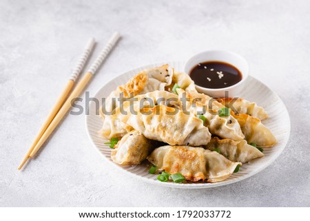 Fried dumplings gyoza with soy sauce, and chopsticks, selective focus.