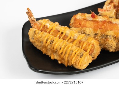 Fried Dynamite Shrimp Roll. sushi roll stuffed with cream cheese, panko coated, topped with panko shrimp, avocado, dynamite sauce crunchy. White Background. Angle Side View Photo