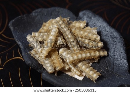 Fried eel bone (hone senbei) in a ceramic dish.