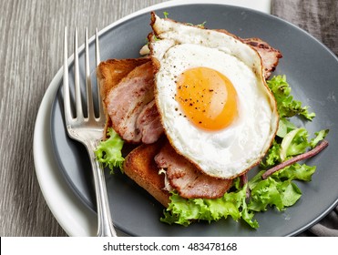 Fried Egg, Bacon And Salad On Grey Plate