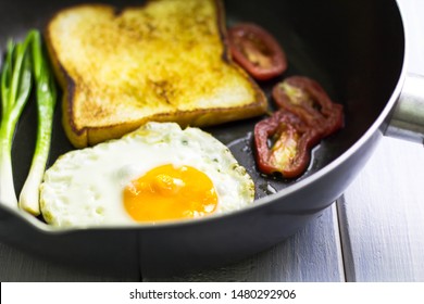 Fried egg and bread in the pan placed on table