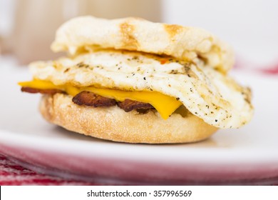 Fried Egg Sandwich With Bacon And Cheddar Cheese On A English Muffin With Coffee