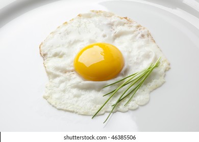  Fried Egg Sunny Side Up With Chive On A White Plate