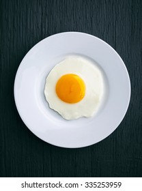 Fried Egg.
Top View Of White Dish With Fried Egg On Wooden Background.