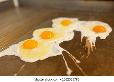 fried eggs on restaurants cooking top, breakfast for kitchen staff and employees