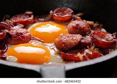 Fried Eggs With Sausage And Onion On Frying Pan

