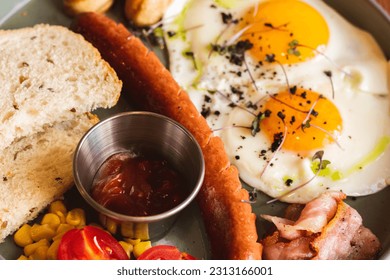 Fried eggs with sausages, tomato and bread on plate. English breakfast in cafe. European breakfast table. Eggs with meat and vegetables. Ready to eat food. Healthy dinner. Restaurant menu. - Powered by Shutterstock