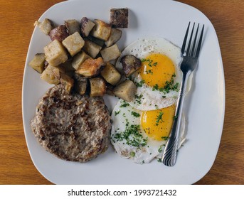 Fried Eggs Top With Parsley And Served With Sausage Patty And Home Fries, 