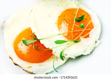 Fried Eggs And Verdure On White Background