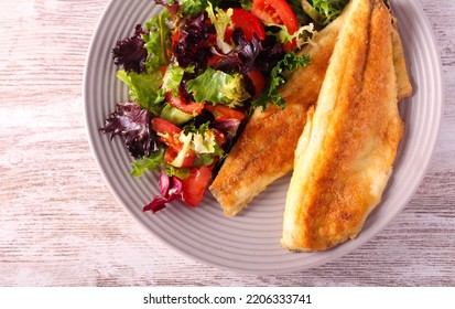 Fried Fillet Of Sea Bass Fish Served With Salad