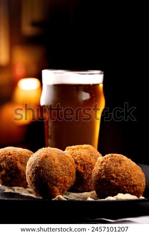 fried fish cake appetizer cod salmon half pint of beer blurred and blurred bar background