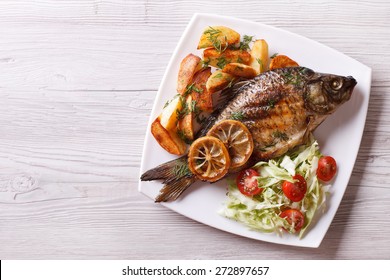 Fried Fish With Fries And Salad On A Plate. Horizontal View From Above 