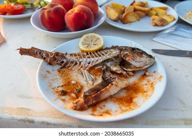 Fried Fish Skeleton In A Plate In A Restaurant.