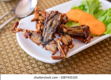 Fried Frogs With Vegetables On White Plate, Cambodian Traditional Dish. Khmer National Food. Cambodia Cuisine. Frog Meat Grilled. Exotic Food Of South Asia. Meat And Vegetables. Cooked Frog Served