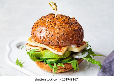 Fried Halloumi Burger With Avocado Wedges And Arugula. Vegetarian Food Concept.