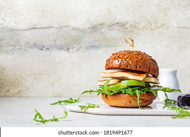 Fried Halloumi Burger With Avocado Wedges And Arugula. Vegetarian Food Concept.