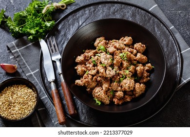 Fried Italian Sausage Of Freshly Ground Pork Meat And Spices In Black Bowl On Concrete Table With Rustic Fork And Knife, Horizontal View Form Above