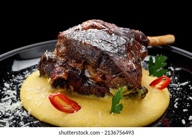 Fried leg of lamb with garnish and pepper, on a dark background