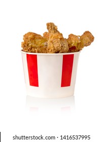 Fried legs and wings on a white background. Chicken wings and legs deep-fried in a cardboard bucket.