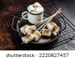 Fried Marshmallow on the sticks with Cup of coffee. Dark background. Top view.