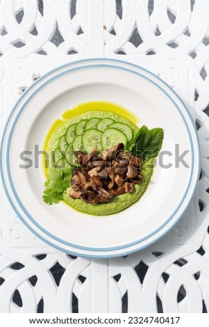 fried mushrooms with green puree and cucumber slice top view with copy space. vegetarian food recipes for cook book or cafe menu.