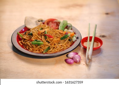 Fried Noodles With Dried Chilli,onion,pickels,tomatoes With Fish Cracker