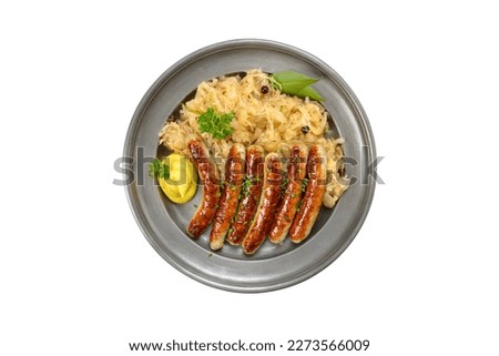 Fried Nuremberg sausages with sauerkraut served on a pewter plate on white background