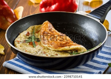 Fried omelets with various autumn vegetables in a frying pan on a wooden table. Autumn recipes. Stockfoto © 