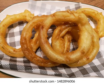 Fried Onions And Oil Blotter On A Plate On The Table
