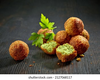 fried organic falafel balls on black wooden table, halafel - Shutterstock ID 2127068117