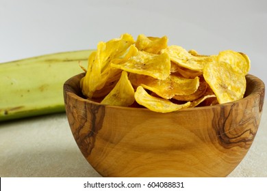 Fried plantain chips in a wooden bowl. Image of homemade healthy snack.