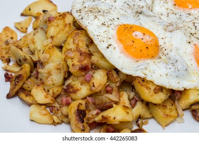 Fried potatoes with bacon and onions and fried egg
