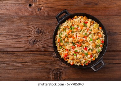 Fried Rice With Chicken. Prepared And Served In A Wok. Natural Wood In The Background. Top View.